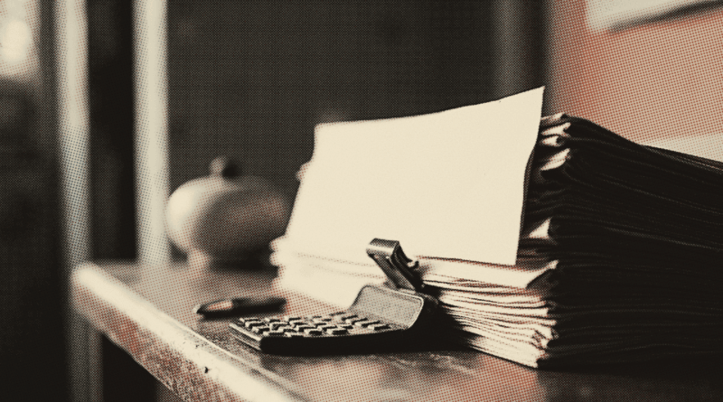 A thick stack of folded papers gripped by a black bulldog clip standing on a desk — CTOS vs CCRIS 2026: How to Check Your Score & Fix It