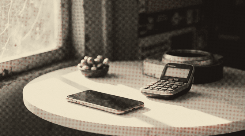 A mobile phone lying face down on a marble-topped table — STR Status Check: Payment Amounts & Payout Dates