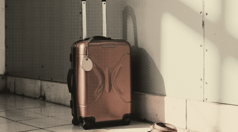 The corner of a hard-shell suitcase standing on an airport floor — Malaysia Passport Visa-Free Countries 2026: Full List