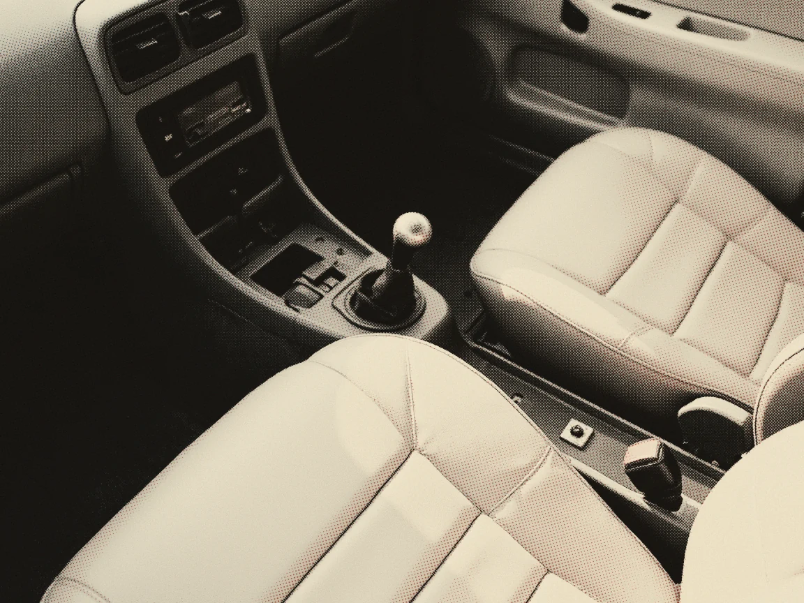 Driving Licence Price Malaysia 2026: Class D & B2 Fees — the gear lever and handbrake between two worn seats inside a parked car