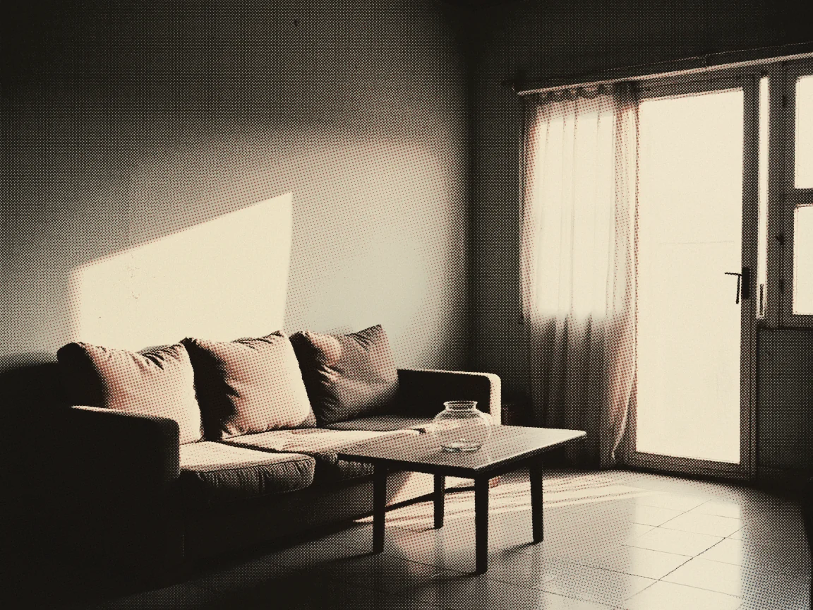 Home Insurance Malaysia 2026: Houseowner vs Householder — a living room corner with a sofa, a low coffee table and afternoon light through an open glass door