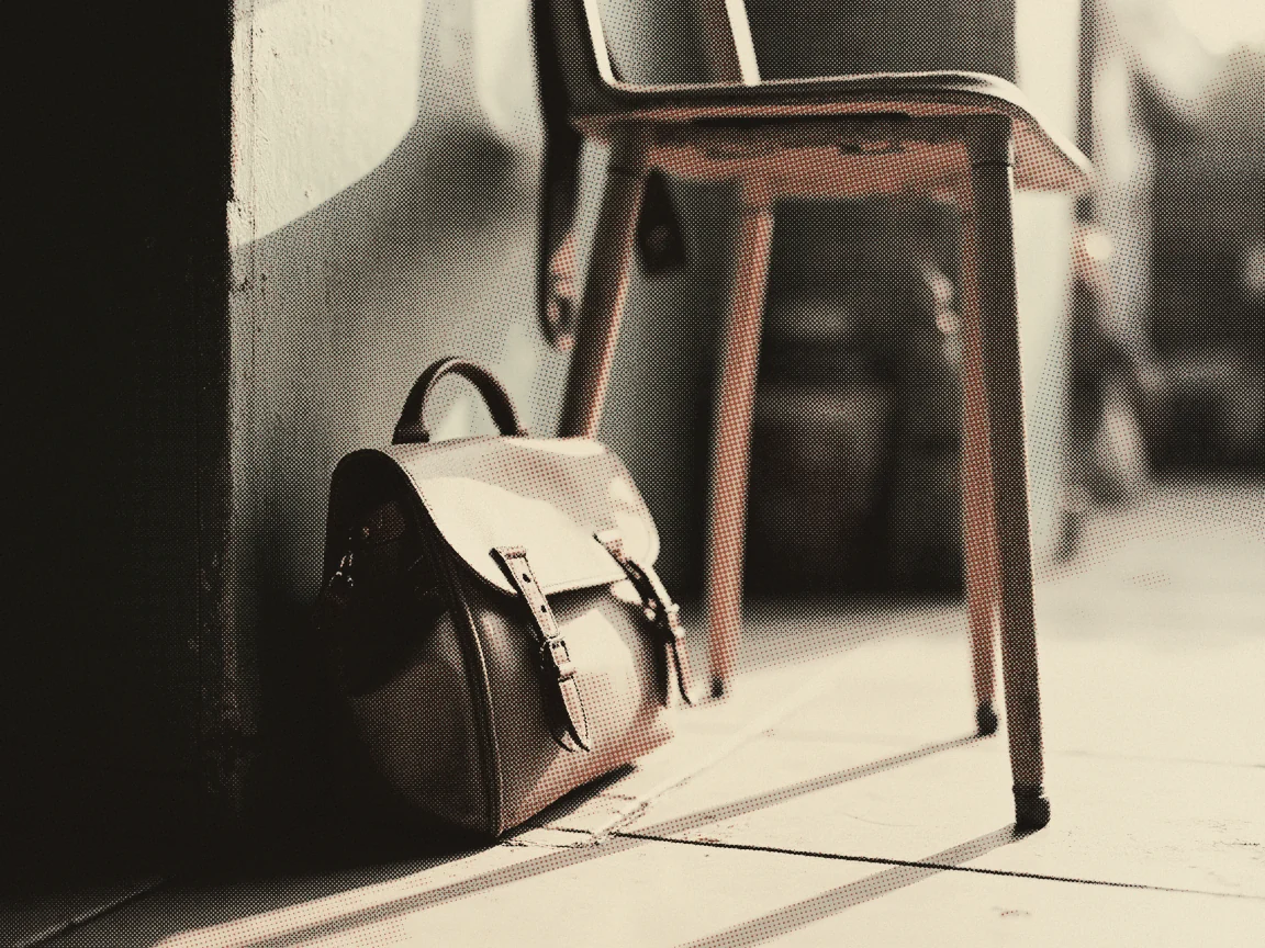 IDME Login 2026: Check School Exam Results Step by Step — a school satchel standing on a tiled floor beside a chair leg